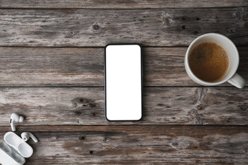 Mobile phone on wooden table showing blank screen, shot from abo