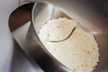 Making pizza background. Pizza dough flour mixing. Kneading machine. Bakery cooking mixer. Kitchen utensil.