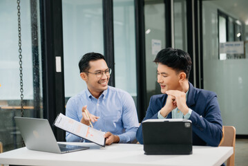 Male discussing new project with business colleague. Young man talking with young man in office.