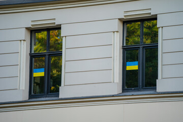 Ukraine flag stickers on windows on building in Europe, Riga, Latvia - obrazy, fototapety, plakaty