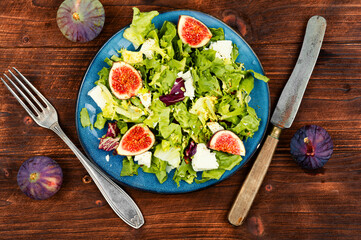 Figs salad with cheese on wooden table
