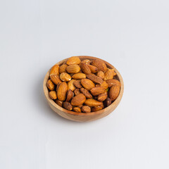 Almonds in wooden bowl. Almonds isolated on white background.
