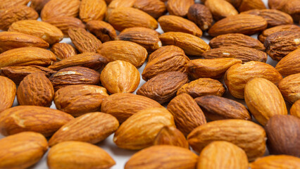 Almonds on white background. Raw peeled almond nuts texture