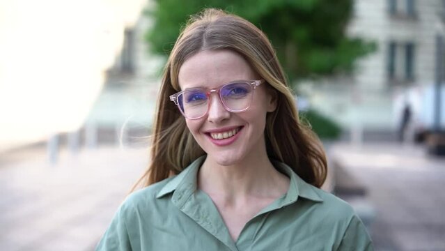 A smart student with glasses training education looks into the camera, a close portrait, smiling sweet woman manager confident.