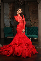 Fashion Woman in Red Dress. Beautiful Model Brunette in Long Evening Gown indoor