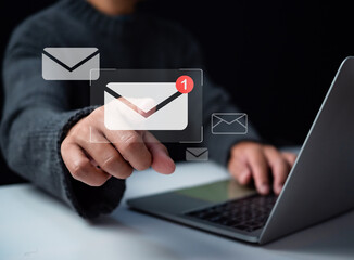 Human hand touching email on virtual screen. New email notification concept for business email communication and digital marketing. The inbox receives electronic message notifications. 