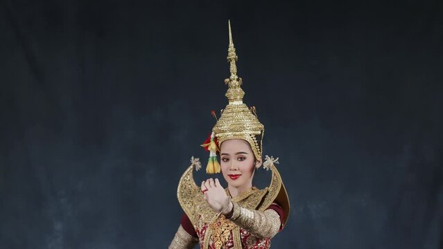 Beautiful Asian woman wear Thai traditional dress action of Thai classical dancing.