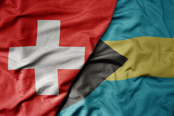 big waving national colorful flag of switzerland and national flag of bahamas .