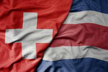 Fototapeta na wymiar big waving national colorful flag of switzerland and national flag of costa rica .