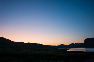 Night sky in twilight in Swedish Lapland arctic summer midnight. Lake Alisjavri on Kungsleden and Nordkalottruta Arctic hiking Trail in northern Sweden