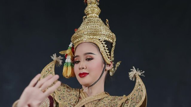 Beautiful Asian woman wear Thai traditional dress action of Thai classical dancing.
