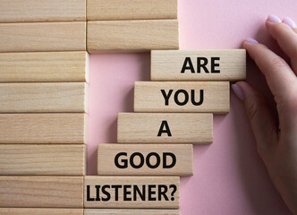 Listening skills symbol. Wooden blocks with words Are you a good Listener. Beautiful pink...