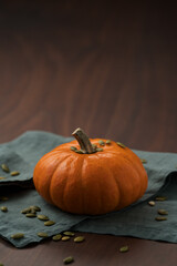 Orange pumpkin on linen napkin on wood table for seasonal background