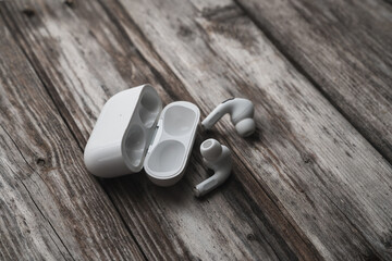 close-up modern wireless earphone on wood background - 645960930