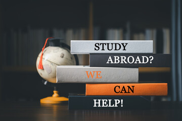 Books with words 'Study Abroad? We Can Help! Concept of global business study, abroad educational, Back to School. Education in Global world, Study abroad business in universities in worldwide.