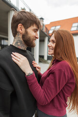 Happy beautiful young couple handsome hipster bearded man and redhead beautiful girl outdoors