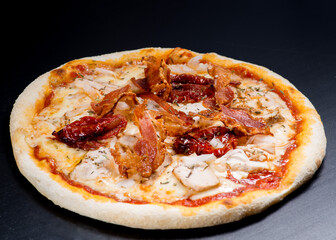 Pizza with chicken, bacon and sun-dried tomatoes.