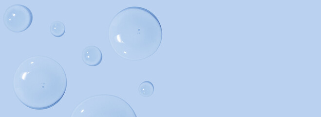 large drops of cosmetic serum, liquid, water, gel on a pink background