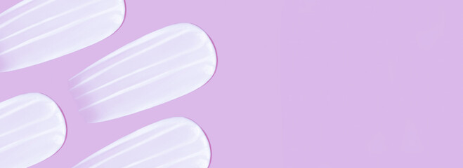 The background is cosmetic. Many smears of cream on a pink pink background