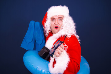 Summer and holidays at sea. A funny drag queen enjoys life in a Santa Claus costume. Blue background.