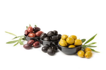 Green, black and red olives isolated on white background. Various types of olives and with fresh olive leaves. Mediterranean food. Vegan.