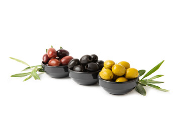 Green, black and red olives isolated on white background. Various types of olives and with fresh olive leaves. Mediterranean food. Vegan.
