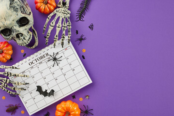 It's time to get set for Halloween. Top view photo of calendar, scary skull, skeleton hands, pumpkins, spooky insects on purple background with promo space