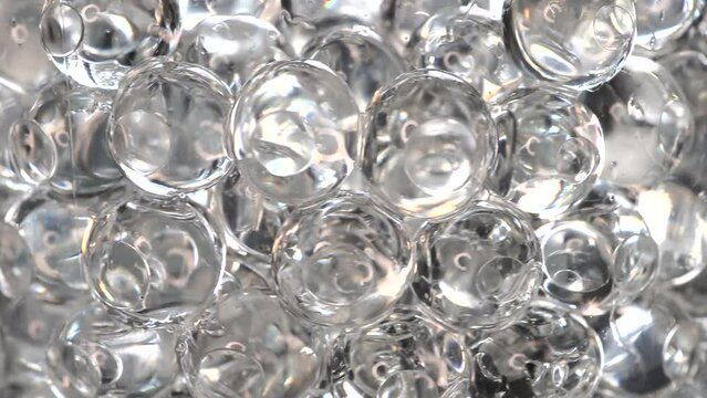 A close-up video of spinning sticky beads in a plastic container