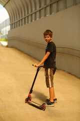 Fototapeta na wymiar Portrait of eleven year old boy with a scooter