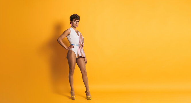 Drag man with sensual fashion clothes posing in a yellow studio