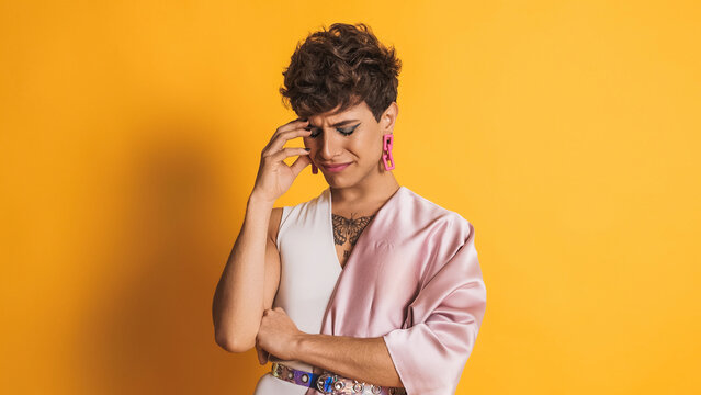 Sad and worried drag man looking at the camera on yellow