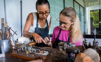Teacher jeweler and student make jewelry in workshop