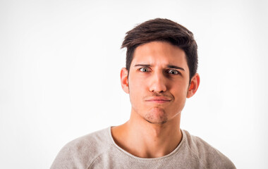Confused young man looking at camera in studio