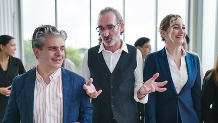 Group of diverse business people talking while walking together at modern office. Group of diverse coworkers discussion while walking the corridor in office together. Multiethnic business people group