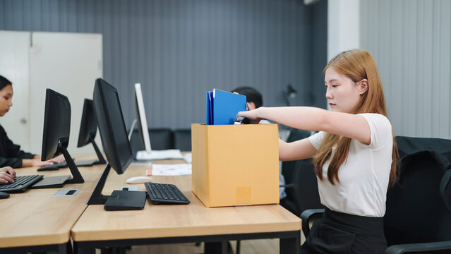 Asian businesswoman packing belongings in cardboard box after fired. Unemployment, Dismissal