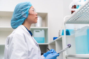 Scientist woman staff in laboratory checking the inventory shelf checklist the equipment stock in storage room in hospital