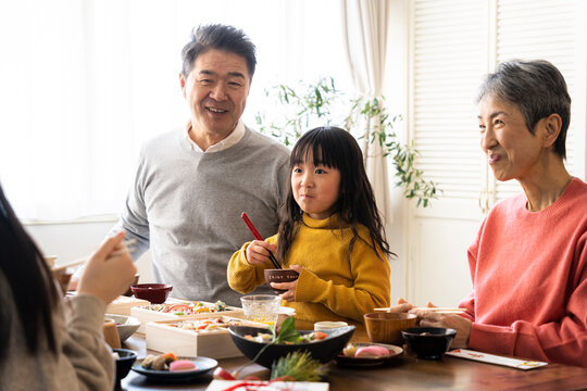 おせち料理を食べる日本人シニア夫婦と孫