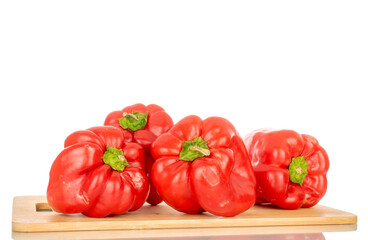 Four red sweet peppers with bamboo kitchen board, macro, isolated on white background.
