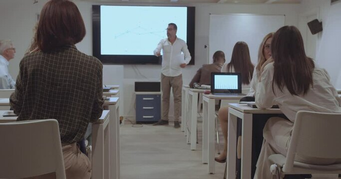 A senior management trainer is instructing employees of a company in new ways of working, trucking motion