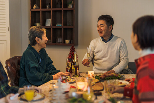 家族とクリスマスパーティーをする日本人シニア夫婦