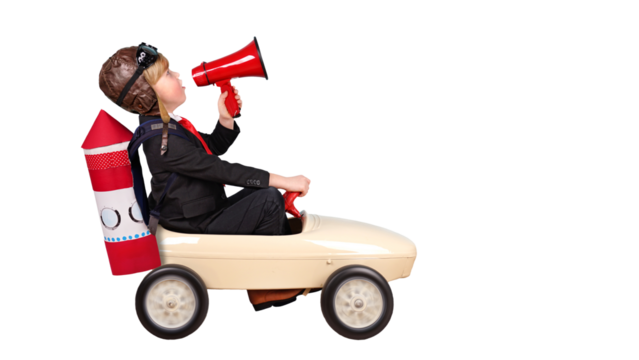 kleiner Junge im Tretauto mit Megafon und Rakete