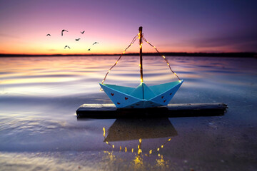 Sonnenuntergang mit beleuchteten Boot am Strand