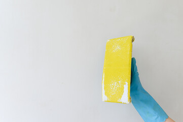 Hand of plasterer at wall polishing. House renovation concept.