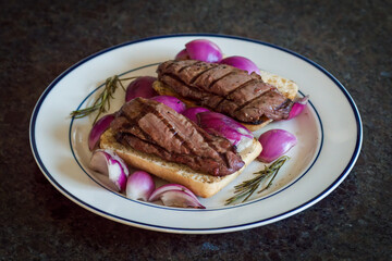 grilled rosa fillet from the chamois yearling with red onions,  rosemary on ciabatta at the hunting season, a very delicious meal
