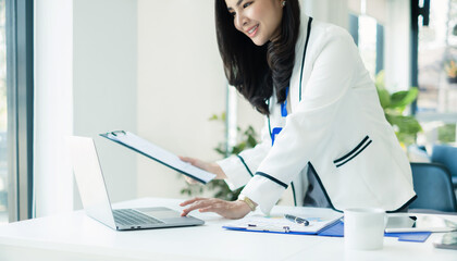 Asian businesswoman sit at their desks and calculate financial graphs showing results about their investments, planning a successful business growth process