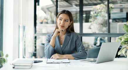Asian businesswoman sit at their desks and calculate financial graphs showing results about their investments, planning a successful business growth process