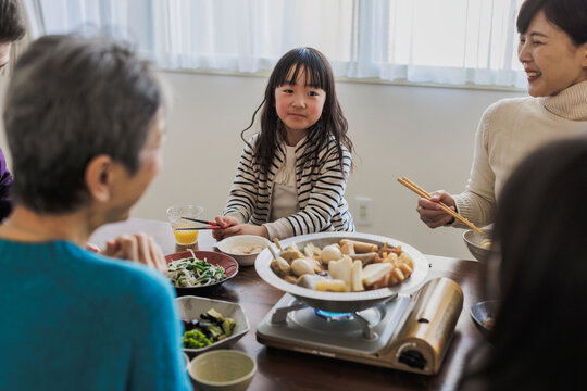 家族とおでんを食べる日本人の女の子