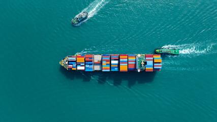 Top view of cargo container ship carrying container and running with tug boat for import export...