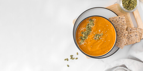 A bowl of pumpkin soup with mashed potatoes and seeds. Autumn menu. Copy space