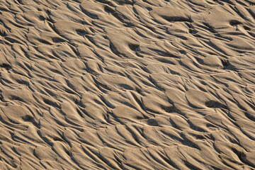 Abstract patterns in sand created by wind and water